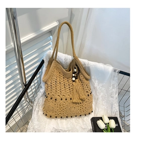 Detail of hand-woven crochet tote bag with black bead accents and a large side tassel