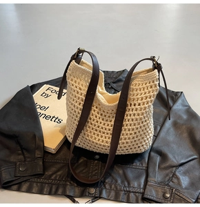 Detail of hand-woven cream tote bag with hollow mesh pattern and brown leather straps