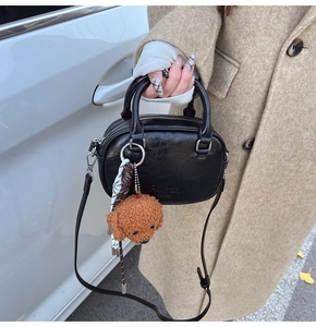 Detail of black textured leather bag with PANTOR SRIES logo and bear charm detail