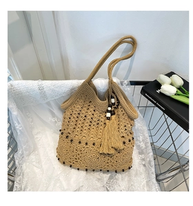 Detail of hollow woven cotton shoulder bag with wooden beads and elegant tassels