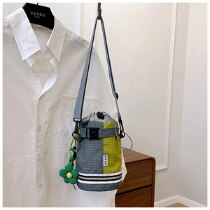 Close-up of checkered drawstring bike bucket bag with neon green flower charm