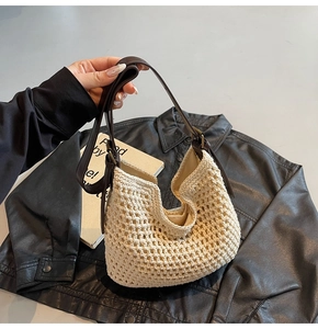 Close-up of woven cotton tote bag with adjustable brown leather strap and metal buckle