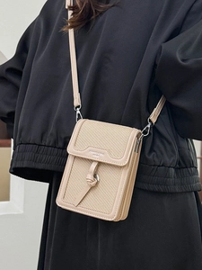 Fashionable woven crossbody phone bag with leather strap shown on a model in minimalist style