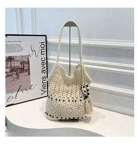 Detailed macro of handmade crochet tote bag featuring wooden beads and thick tassels