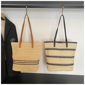 Détail de sacs cabas en paille tressée avec lanières en similicuir et rayures tendance