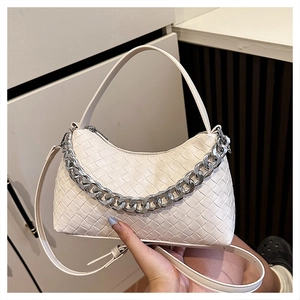 Detail of cream woven leather hobo bag with thick silver chain strap and grid pattern