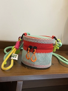 Vibrant light blue mesh cylinder crossbody bag with colorful woven rope shoulder strap