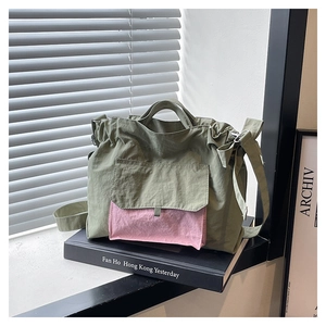 Détail du sac cabas en nylon vert et rose avec texture froissée et bandoulière réglable