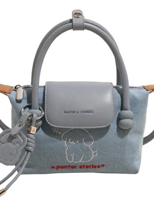 Denim dumpling handbag with puppy print and blue leather flap in a minimalist style