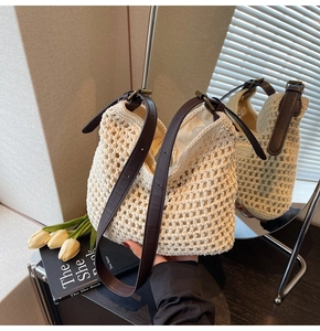 Detailed shot of cream crochet tote bag with brown leather strap and metal buckle