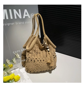 Detail of handmade crochet hollow tote bag with tassels and wooden beads decor