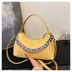 Detail of yellow woven leather hobo bag with silver chain and top zipper closure