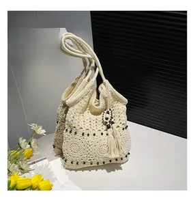 Detail of hand-woven crochet tote with floral patterns and side tassel accents