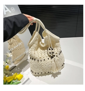 Detail of bohemian crochet tote with floral openwork, wooden beads and fringe tassel