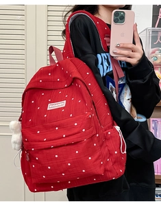Detailed view of the red floral print backpack with side drawstring and brand label