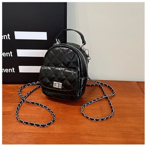 Detailed macro view of black quilted glossy leather mini bag with silver rotating lock