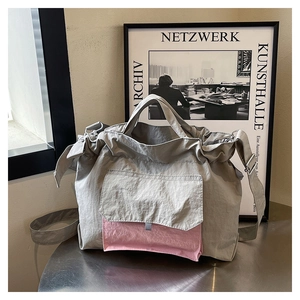 Détail du sac cabas en nylon avec tissu gris plissé et poche avant rose