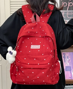 Detail of red floral backpack with plush pendant and white Budaren logo on front