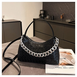 Detailed view of black woven leather texture and thick silver metal chain accessory