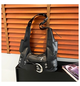 Close-up of black leather shoulder bag featuring oversized silver buckle and zipper details