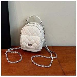 Macro shot of white quilted leather texture with silver metal chain and twist-lock detail