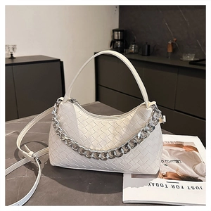 Macro detail of white woven hobo bag featuring chunky silver chain and vegan leather strap