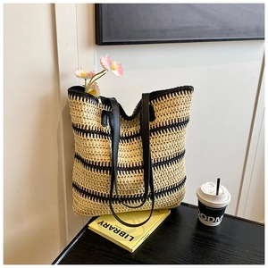 Détail du grand sac cabas en paille tissée à rayures noires et fermeture éclair en métal