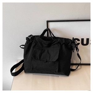 Détail du sac cabas en nylon noir avec poche avant et bandoulière réglable pratique