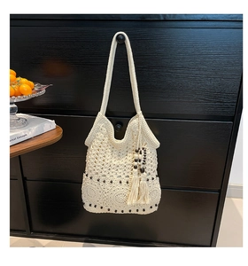 Detailed crochet patterns on beige woven tote bag with dark beads and long tassels