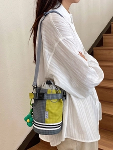 Checkered color-block cycling bucket bag with drawstring and floral charm