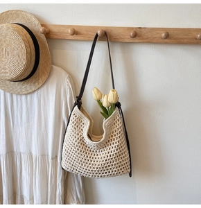 Close-up of beige crochet tote bag with brown leather straps and tulip accents