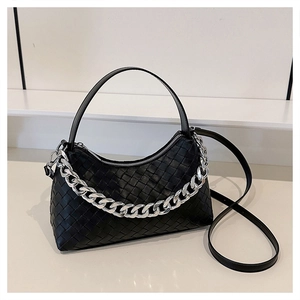 Detail of black woven leather handbag with chunky silver chain and zip closure