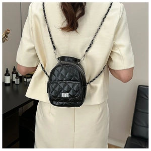 Detail of black quilted mini backpack with silver twist lock and leather chain strap