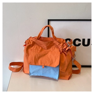 Détail du sac cabas en nylon avec design bicolore orange et bleu clair et cordon de serrage