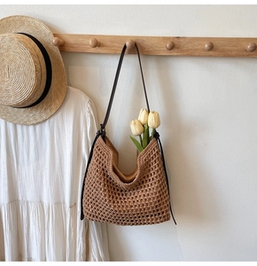 Detail of a brown hand-woven crochet shoulder bag with inner lining and leather strap