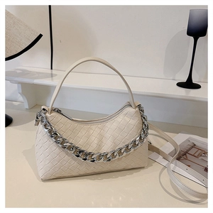 Detailed view of cream woven leather handbag with silver chain and leather strap