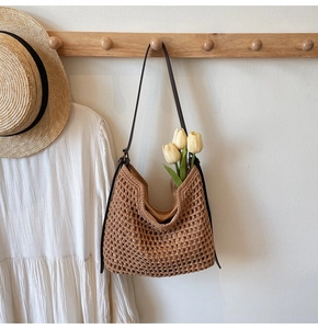 Detail of woven hobo bag featuring caramel cotton mesh and adjustable leather strap