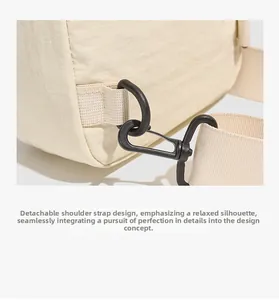 Détail d'un sac bandoulière en nylon crème avec bandoulière tissée amovible et crochet mat