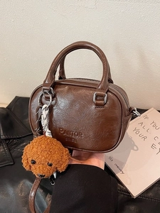Classic dark brown Boston handbag in pebbled faux leather with a cute plush dog charm
