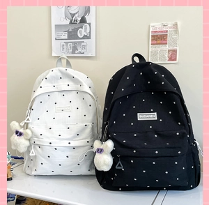 Close-up of floral pattern canvas backpacks with cute plush bear charms for students