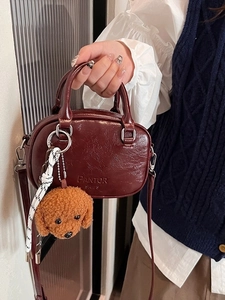 Deep wine red textured leather handbag with plush bear charm and silver hardware
