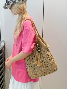 Beige boho crochet tote bag with fringe and black beads, perfect for summer beach vacations