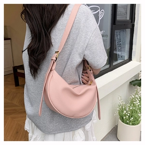 Model trägt eine rosa Halbmond-Tasche aus strukturiertem Leder mit verstellbarem Riemen