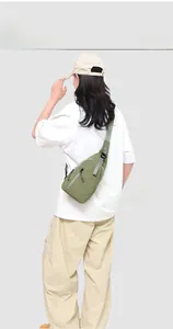 Vue détaillée du dos d'un sac bandoulière vert résistant à l'eau avec sangle