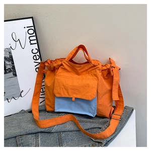 Détail du sac cabas en nylon orange avec poche contrastée bleue et détails de cordon serrage
