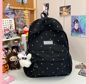 Detail of floral pattern on black backpack with a cute plush rabbit pendant charm
