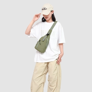 Détail du sac bandoulière en nylon vert avec sangle réglable et compartiments zippés
