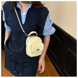 Quilted beige mini crossbody bag with leather chain strap and metal lock closure