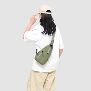 Détail de la sangle réglable et du tissu en nylon vert olive du sac de poitrine sport