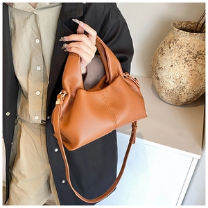 Dettaglio della borsa in pelle martellata marrone arancio con eleganti finiture oro